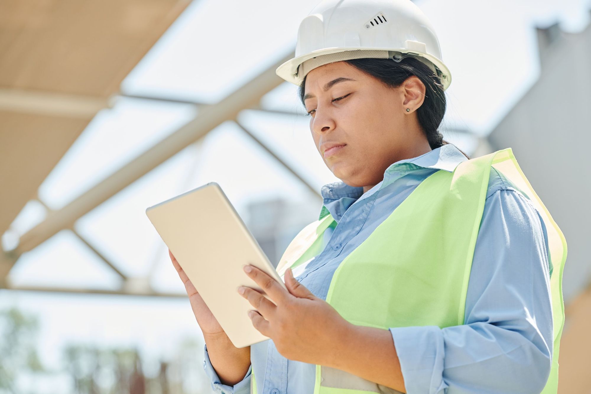 Une inspectrice consulte une attestation sur sa tablette, sur un chantier